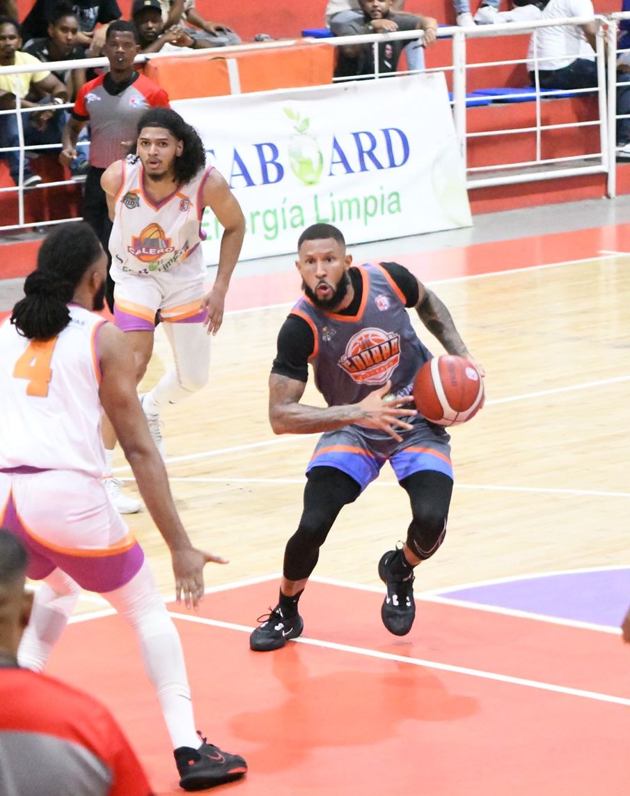 Jayson Valdez, de Caobas City, defendido por Alex Castillo y Axel Goris, de Calero.