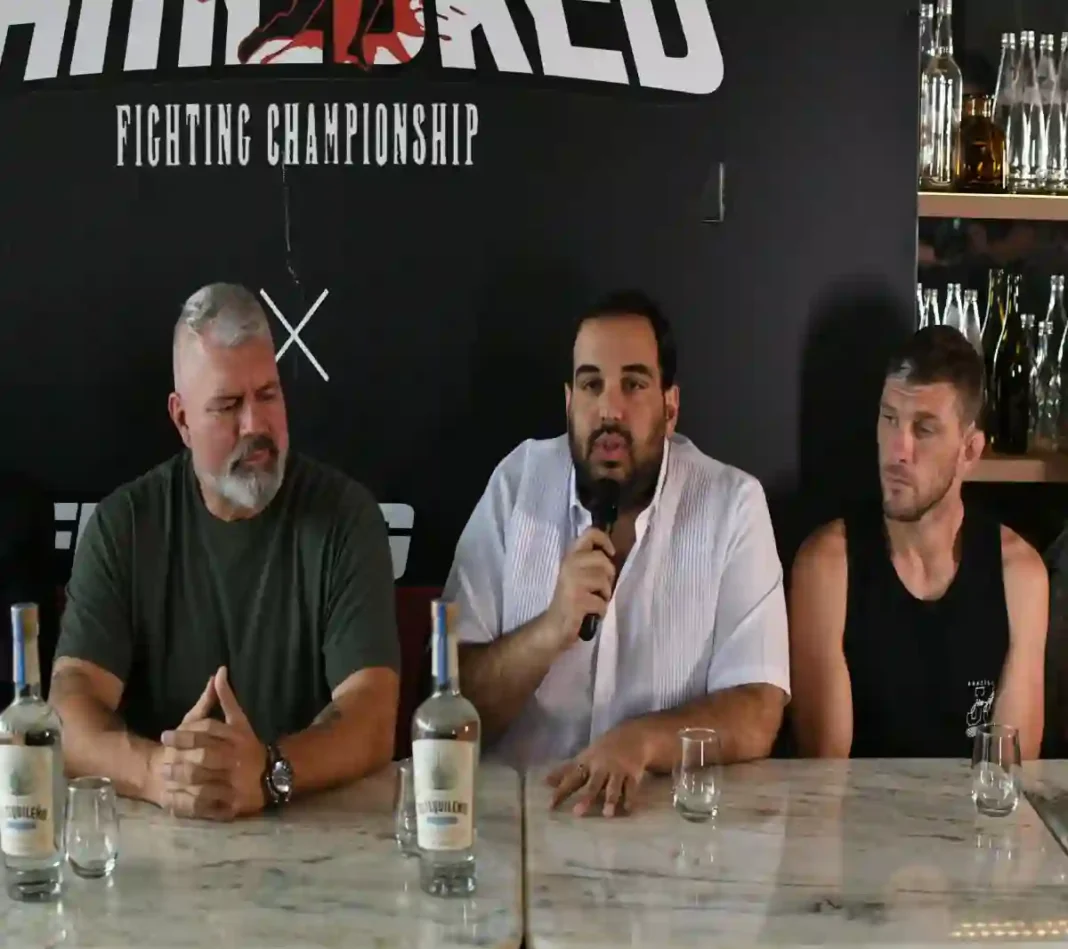 Rodolfo Dauhajre, junto a Lex McMahon y uno de los atletas, ofrece detalles en la rueda de prensa (1)